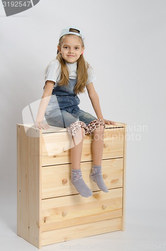 Image of Girl in overalls collector relies on the chest shows class