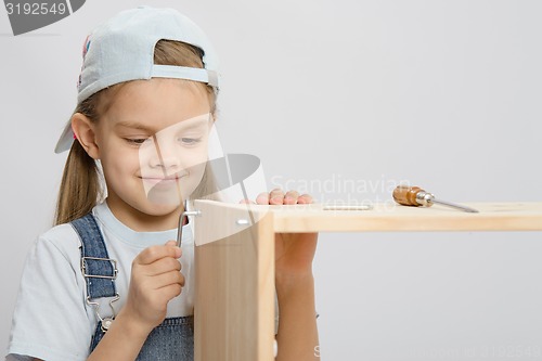 Image of Girl clothing collector furniture trying to screw