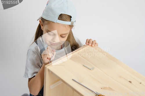 Image of Little girl in the image of garbage furniture screw spins