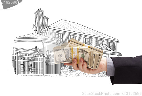 Image of Hand Holding Thousands In Cash Over House Drawing