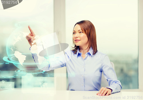 Image of smiling woman pointing to earth hologram