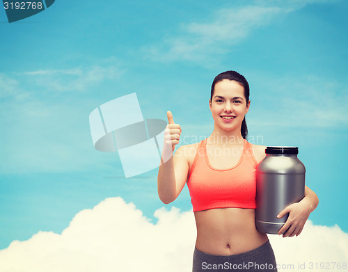 Image of teenage girl with jar of protein showing thumbs up