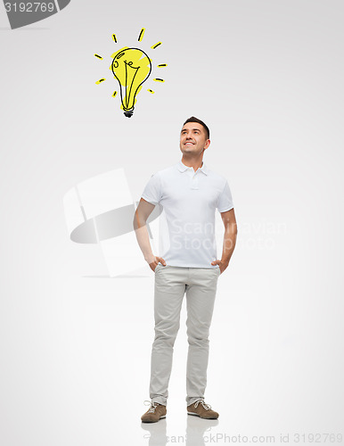 Image of smiling man looking up to lighting bulb