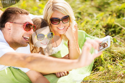 Image of happy family with camera taking picture