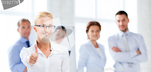 Image of businesswoman in office showign thumbs up