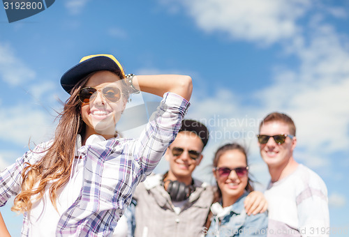 Image of teenage girl with headphones and friends outside