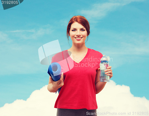 Image of smiling girl with bottle of water after exercising