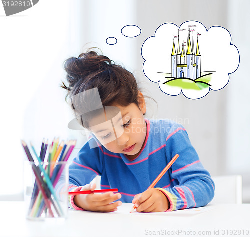 Image of happy little girl drawing castle with crayons