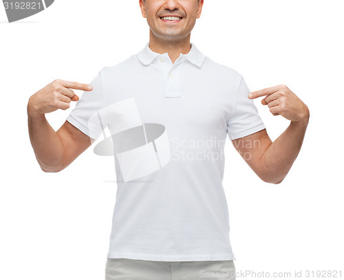 Image of smiling man in t-shirt pointing fingers on himself