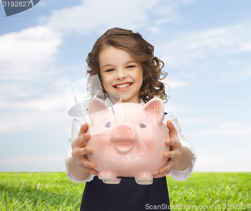 Image of happy girl holding piggy bank 