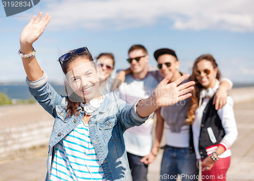 Image of teenage girl with headphones and friends outside