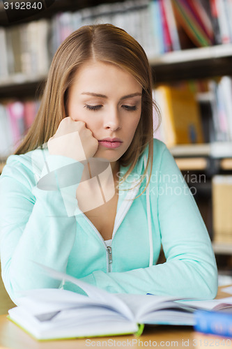 Image of student girl reading book in library