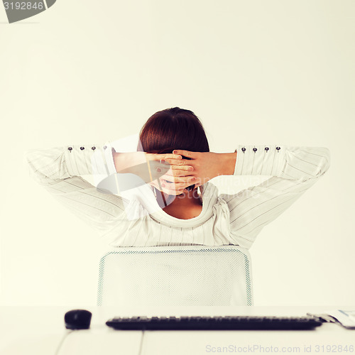 Image of relaxed woman from the back with arms on head