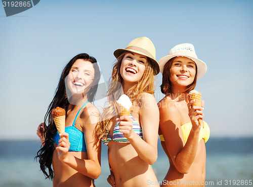 Image of girls in bikinis with ice cream on the beach