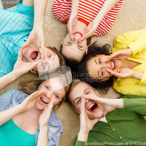 Image of smiling people lying down on floor and screaming