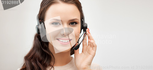 Image of friendly female helpline operator with headphones
