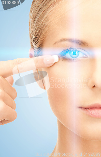 Image of beautiful woman pointing to eye