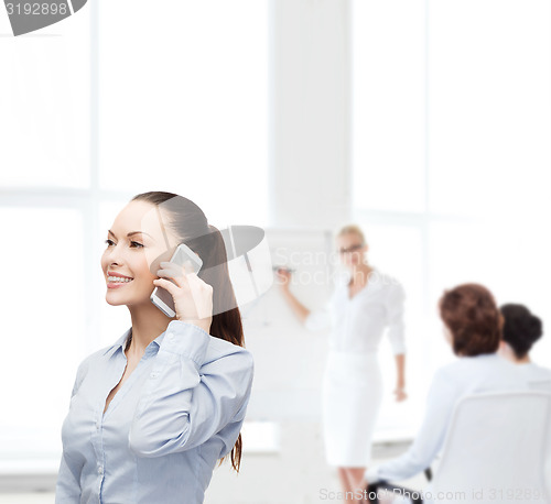 Image of young smiling businesswoman with smartphone