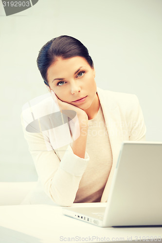 Image of pensive woman with laptop computer