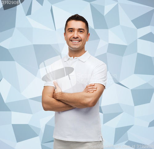 Image of smiling man in white t-shirt with crossed arms