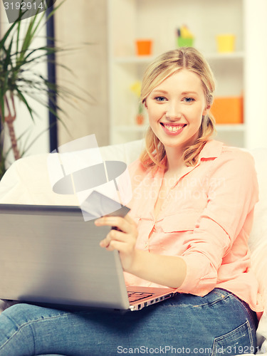 Image of happy woman with laptop computer and credit card