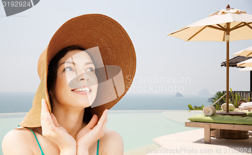 Image of happy young woman in straw hat on tropical beach