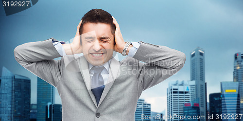 Image of businessman in suit having head ache