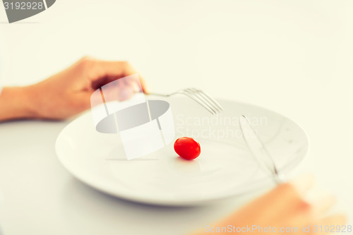 Image of woman with plate and one tomato