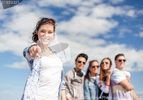 Image of teenage girl with headphones and friends outside