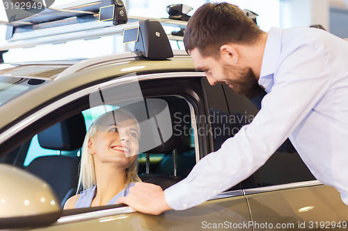 Image of happy couple buying car in auto show or salon