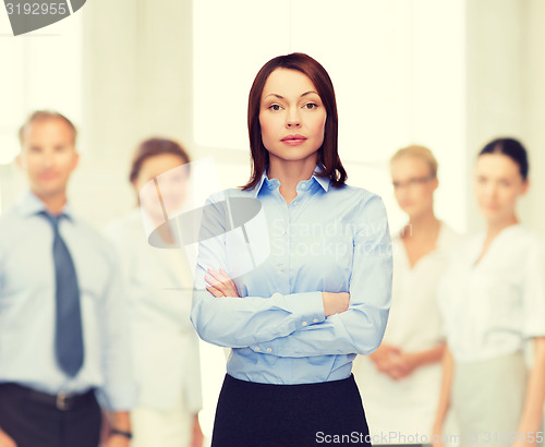 Image of smiling businesswoman with crossed arms at office