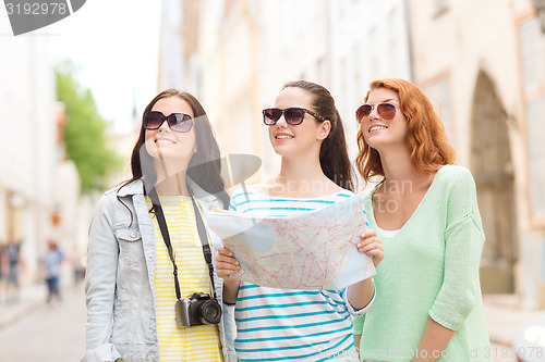Image of smiling teenage girls with map and camera