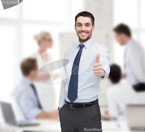 Image of handsome businessman showing thumbs up