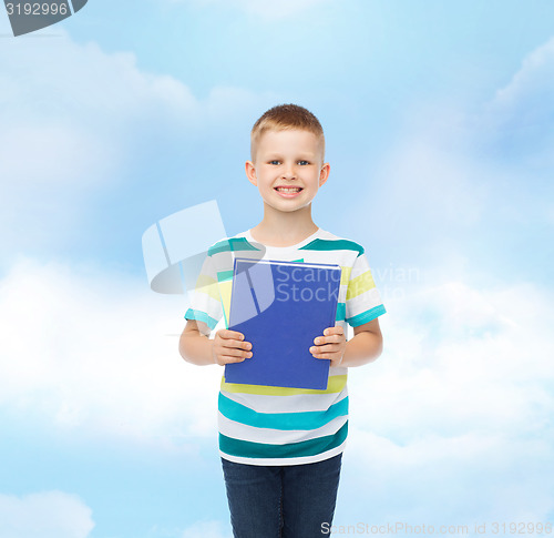 Image of smiling little student boy with blue book