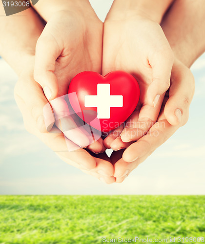 Image of male and female hands with red heart