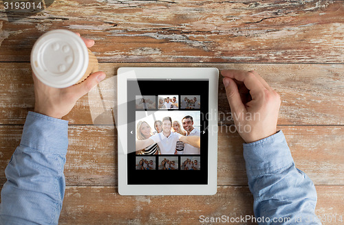 Image of close up of male hands with photo on tablet pc