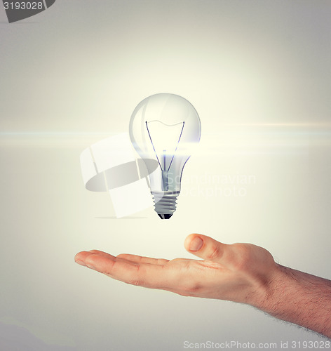 Image of man hand with light bulb