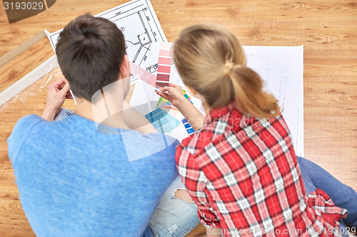 Image of close up of couple with blueprint and palettes