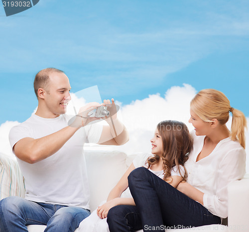 Image of happy family with camera at home