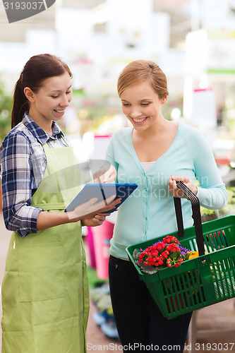 Image of happy women with tablet pc in greenhouse