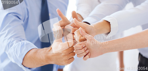 Image of business team showing thumbs up in office