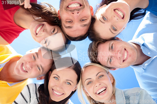 Image of smiling friends in circle on summer beach