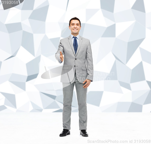Image of happy smiling businessman in suit shaking hand