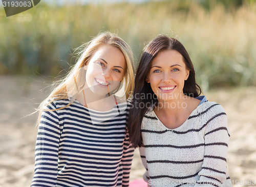 Image of happy teenage girls or young women on beach