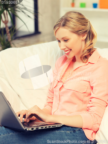 Image of woman with laptop typing  at home