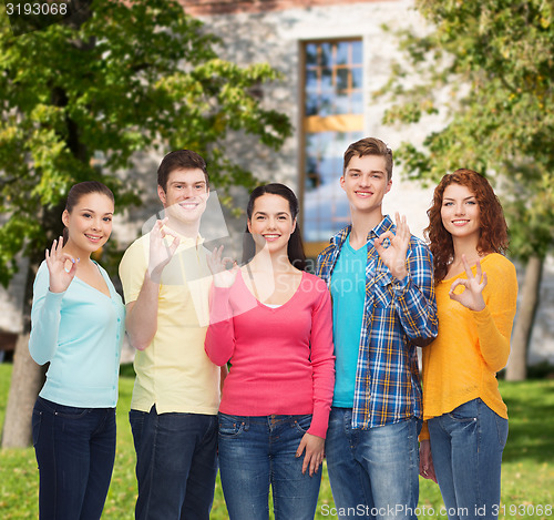 Image of group of smiling teenagers over campus background