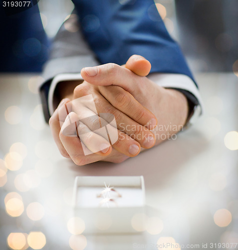 Image of close up of male gay couple and wedding rings