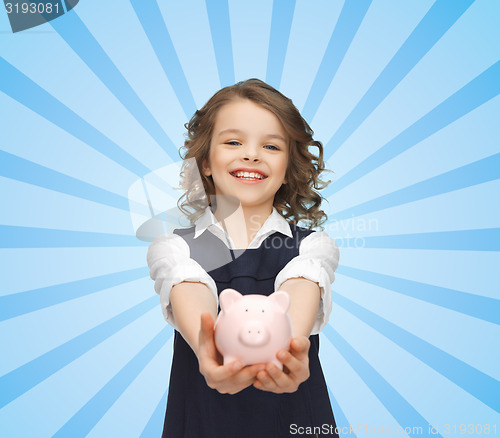 Image of happy girl holding piggy bank on palms