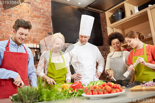 Image of happy friends and chef cook cooking in kitchen