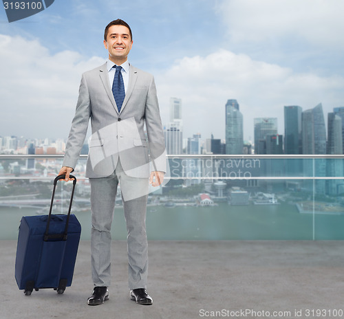 Image of happy businessman in suit with travel bag